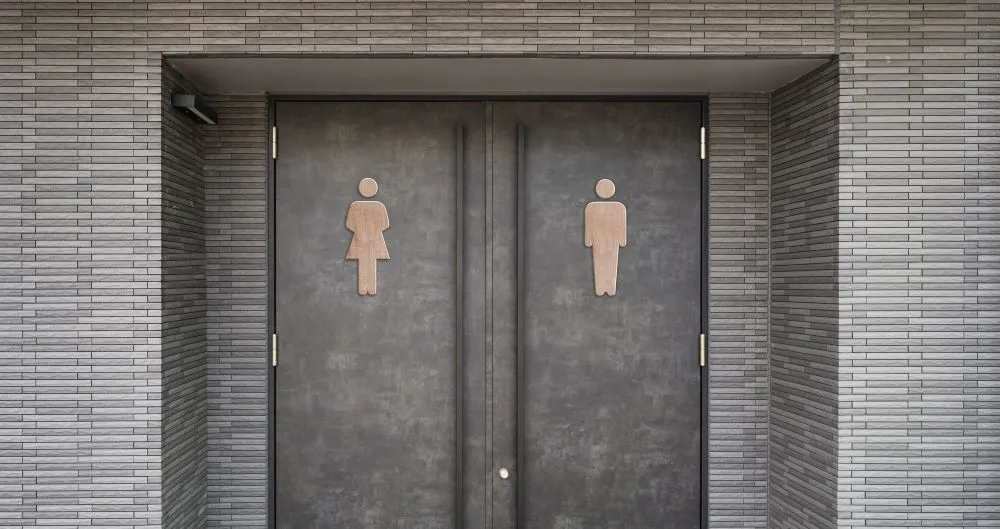 Deux sanitaires publics automatiques avec les portes fermées dans un espace public urbain.